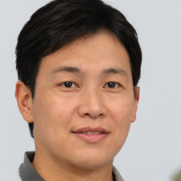 Joyful asian young-adult male with short  brown hair and brown eyes