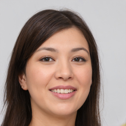 Joyful white young-adult female with long  brown hair and brown eyes