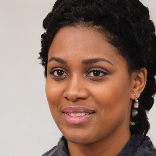 Joyful black young-adult female with medium  black hair and brown eyes