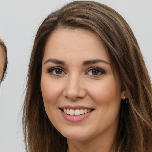 Joyful white young-adult female with long  brown hair and brown eyes