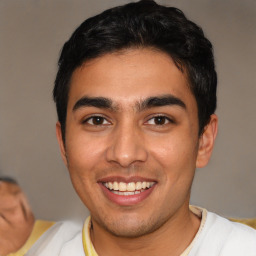 Joyful latino young-adult male with short  brown hair and brown eyes