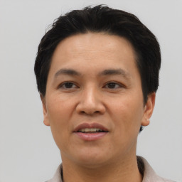 Joyful asian adult male with short  brown hair and brown eyes