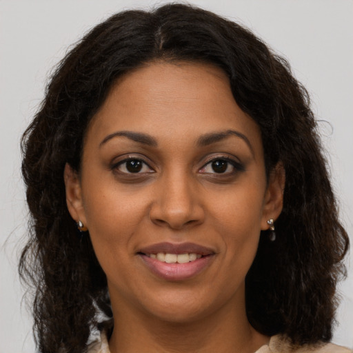 Joyful black young-adult female with long  brown hair and brown eyes