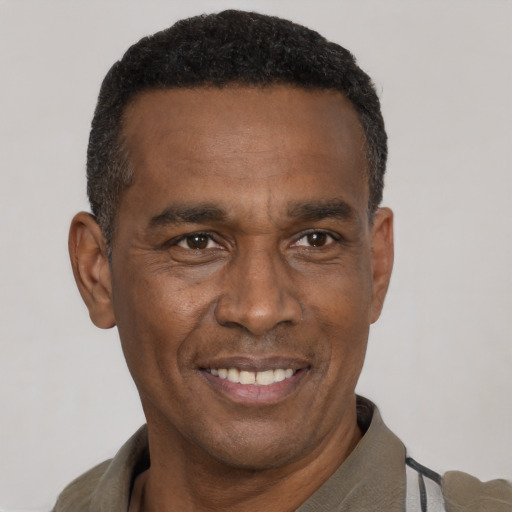 Joyful black adult male with short  black hair and brown eyes