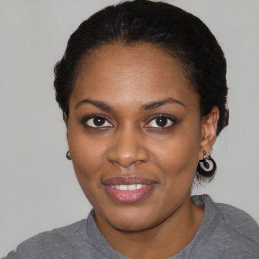 Joyful black young-adult female with short  black hair and brown eyes