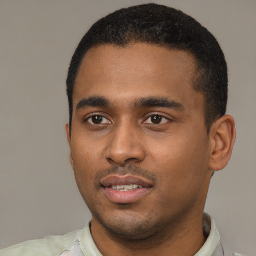 Joyful black young-adult male with short  black hair and brown eyes