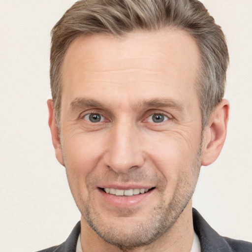 Joyful white adult male with short  brown hair and brown eyes