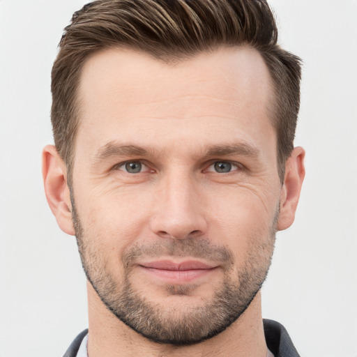 Joyful white young-adult male with short  brown hair and grey eyes