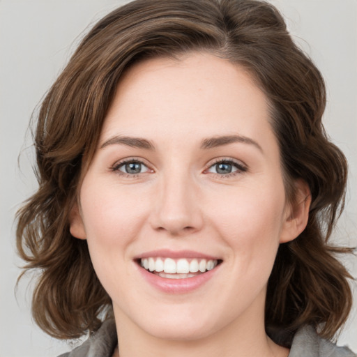 Joyful white young-adult female with medium  brown hair and green eyes