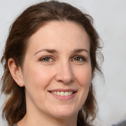 Joyful white adult female with medium  brown hair and grey eyes