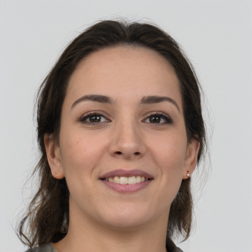 Joyful white young-adult female with medium  brown hair and grey eyes