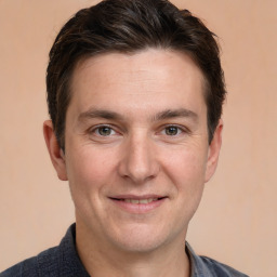 Joyful white young-adult male with short  brown hair and grey eyes