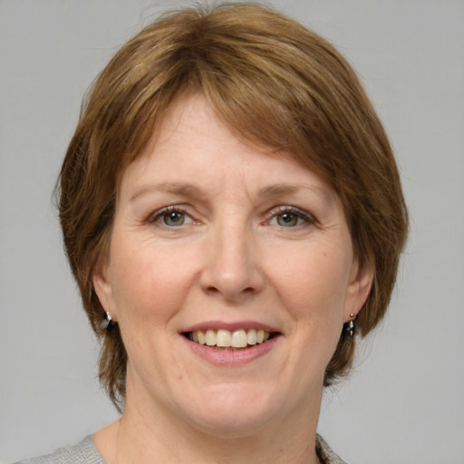 Joyful white adult female with medium  brown hair and grey eyes