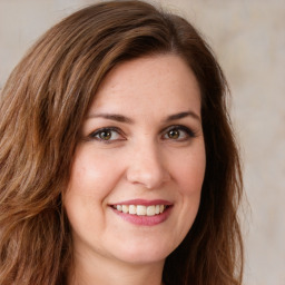 Joyful white young-adult female with long  brown hair and green eyes