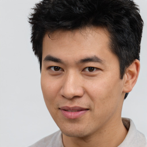 Joyful asian young-adult male with short  brown hair and brown eyes