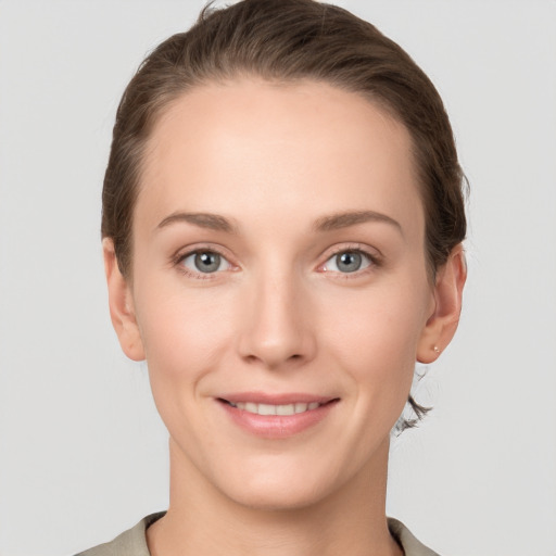 Joyful white young-adult female with short  brown hair and grey eyes