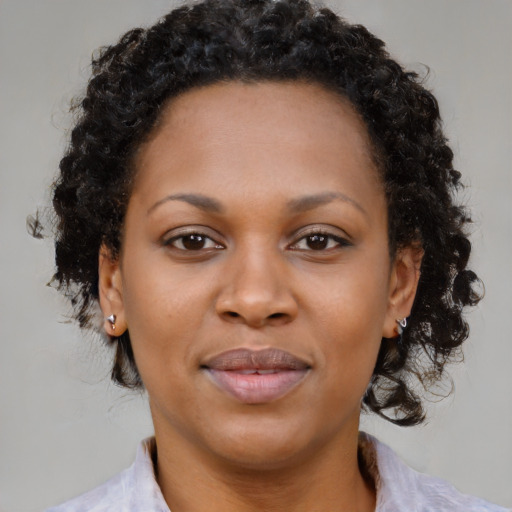 Joyful black young-adult female with medium  brown hair and brown eyes