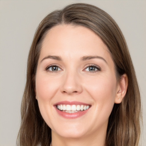 Joyful white young-adult female with long  brown hair and brown eyes