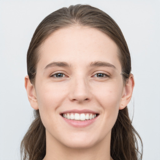 Joyful white young-adult female with long  brown hair and grey eyes