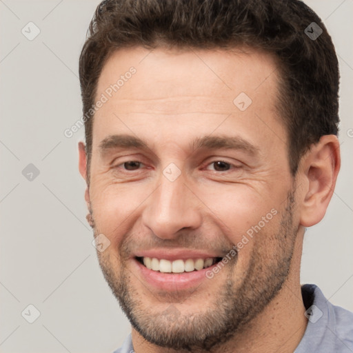 Joyful white adult male with short  brown hair and brown eyes