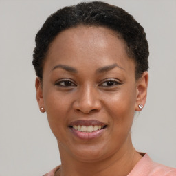 Joyful black young-adult female with short  brown hair and brown eyes