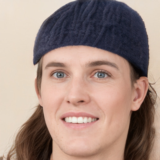 Joyful white young-adult male with medium  brown hair and blue eyes