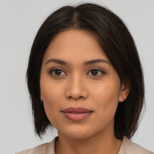 Joyful latino young-adult female with medium  brown hair and brown eyes