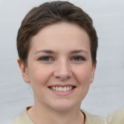 Joyful white young-adult female with short  brown hair and grey eyes