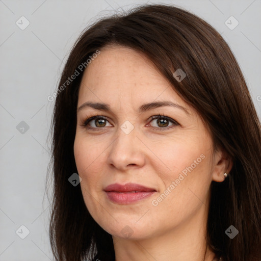 Joyful white adult female with long  brown hair and brown eyes