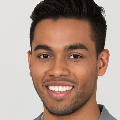 Joyful black young-adult male with short  brown hair and brown eyes