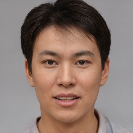Joyful asian young-adult male with short  brown hair and brown eyes