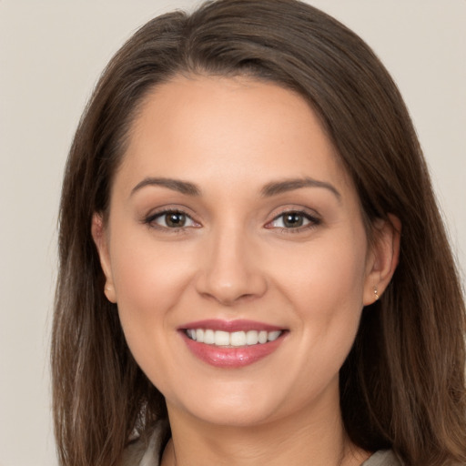 Joyful white young-adult female with long  brown hair and brown eyes