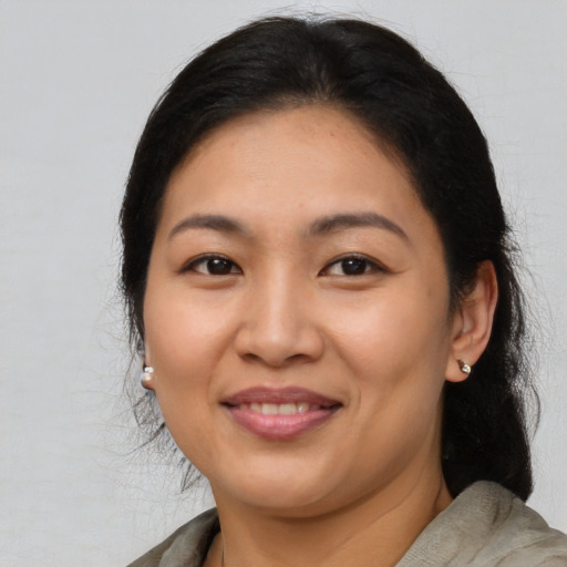 Joyful latino adult female with medium  brown hair and brown eyes