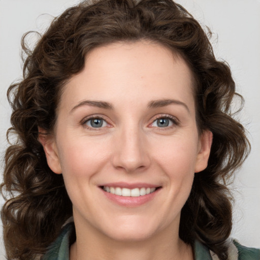 Joyful white young-adult female with medium  brown hair and green eyes