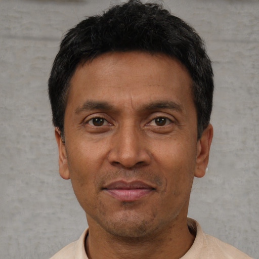 Joyful latino adult male with short  black hair and brown eyes