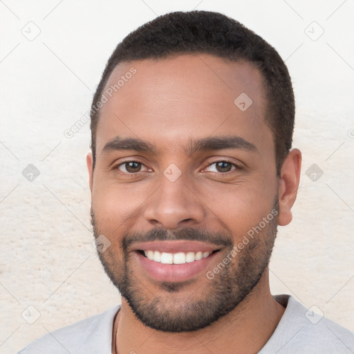 Joyful black young-adult male with short  brown hair and brown eyes