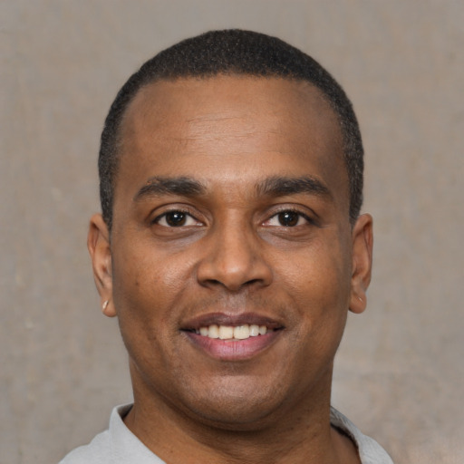 Joyful black young-adult male with short  black hair and brown eyes