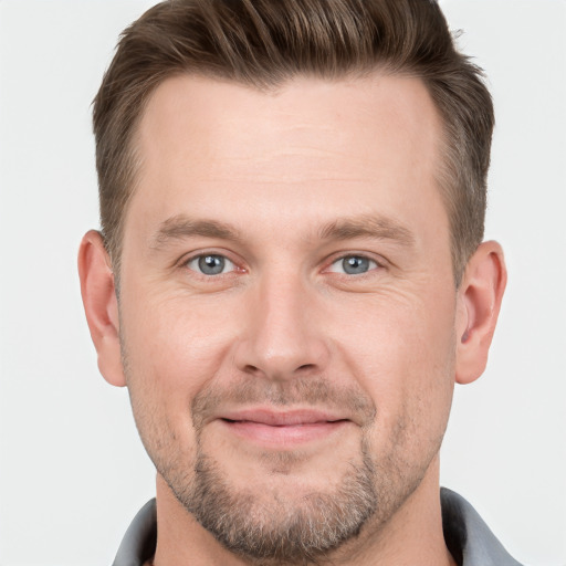 Joyful white young-adult male with short  brown hair and grey eyes