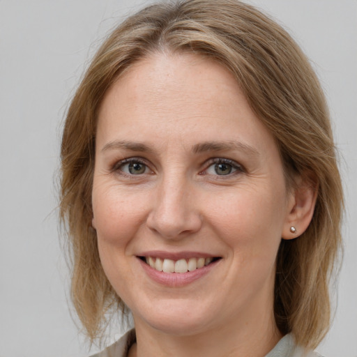 Joyful white adult female with medium  brown hair and grey eyes