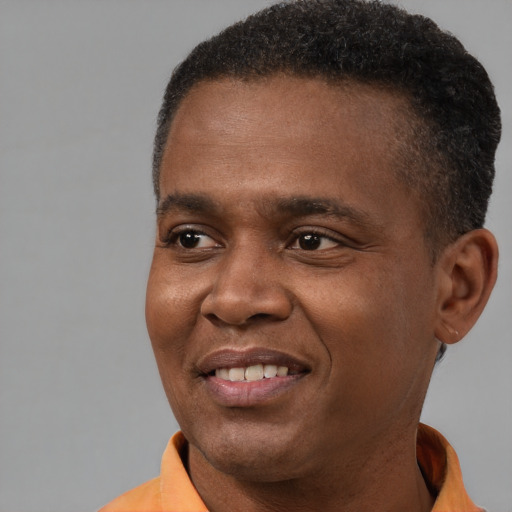 Joyful black young-adult male with short  brown hair and brown eyes