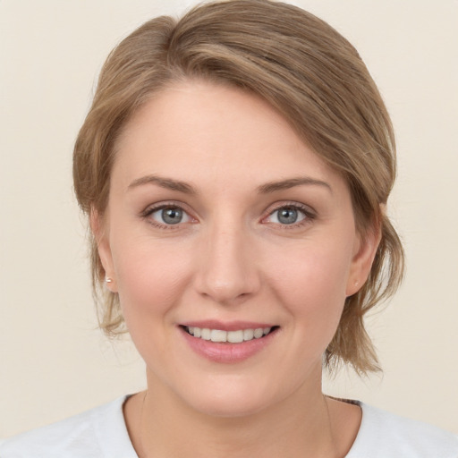 Joyful white young-adult female with medium  brown hair and green eyes