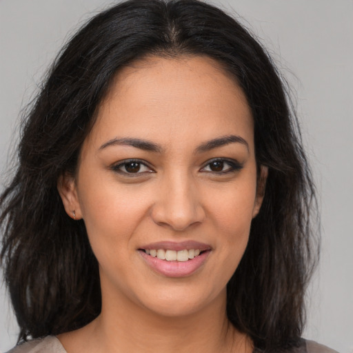 Joyful latino young-adult female with medium  brown hair and brown eyes