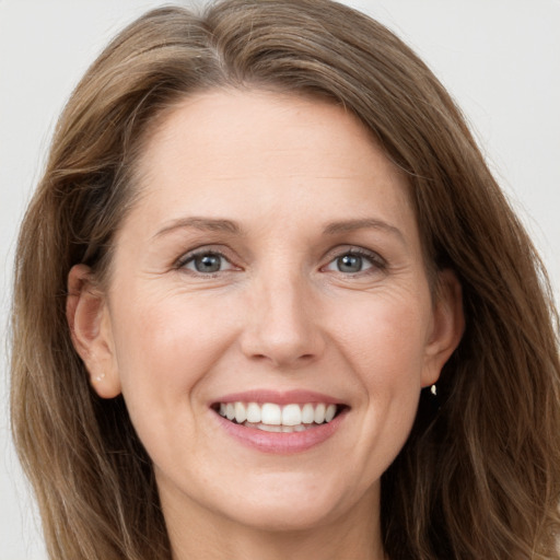 Joyful white adult female with long  brown hair and grey eyes