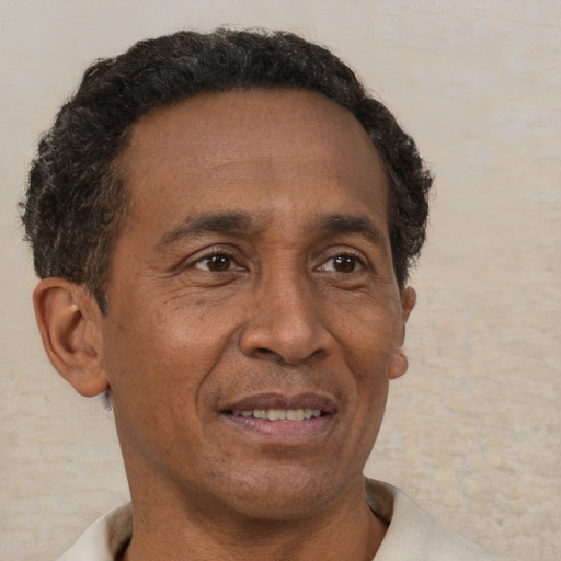 Joyful latino adult male with short  brown hair and brown eyes