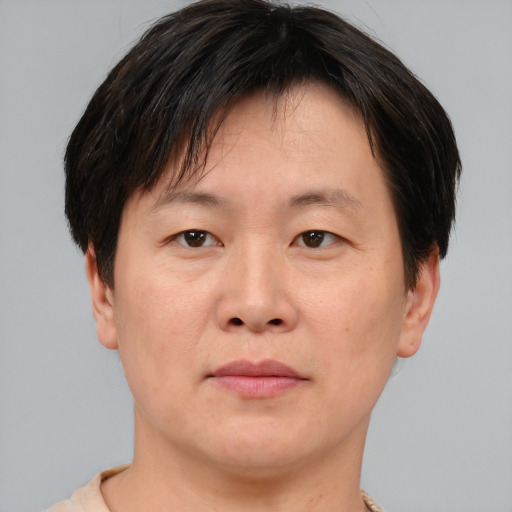 Joyful asian adult male with short  brown hair and brown eyes