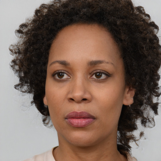 Joyful black young-adult female with medium  brown hair and brown eyes