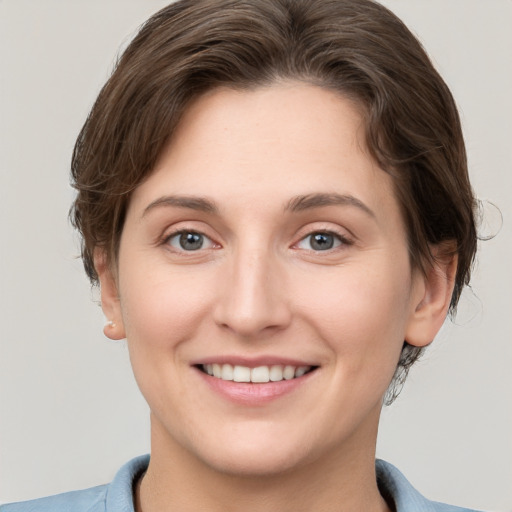 Joyful white young-adult female with short  brown hair and grey eyes