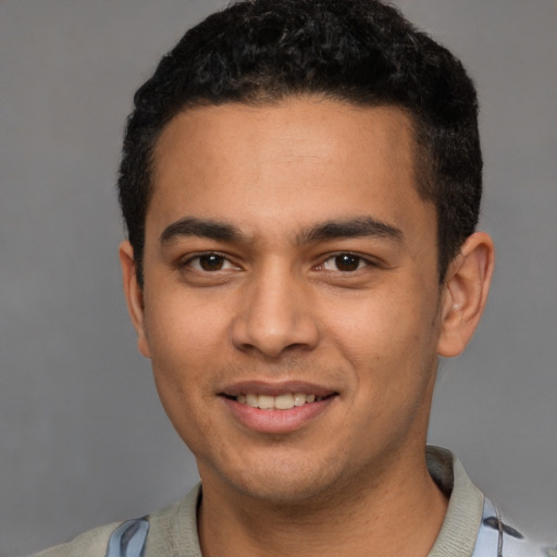 Joyful latino young-adult male with short  black hair and brown eyes