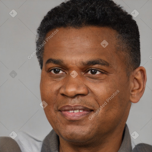 Joyful black adult male with short  black hair and brown eyes