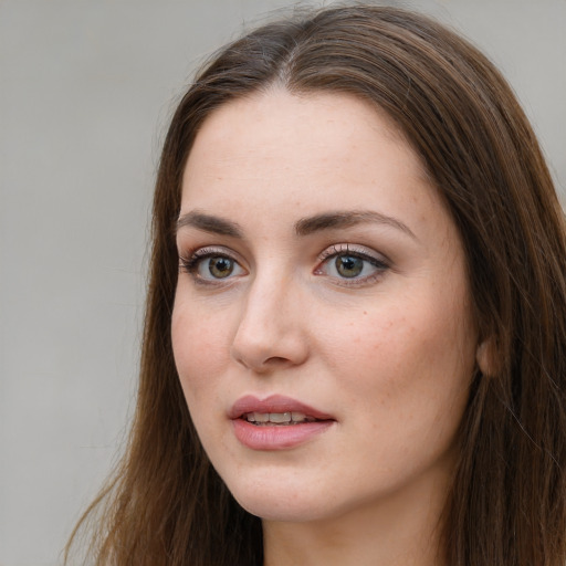 Joyful white young-adult female with long  brown hair and green eyes